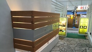 Ein Empfangsschalter mit Holzlamellen-Design und einer Glasscheibe, der zu einer Zimmerauskunft führt.