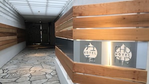 Ein Flur mit Steinmuster-Boden, Holzwandverkleidung und einem Schild, das den Namen des Hotels angibt.