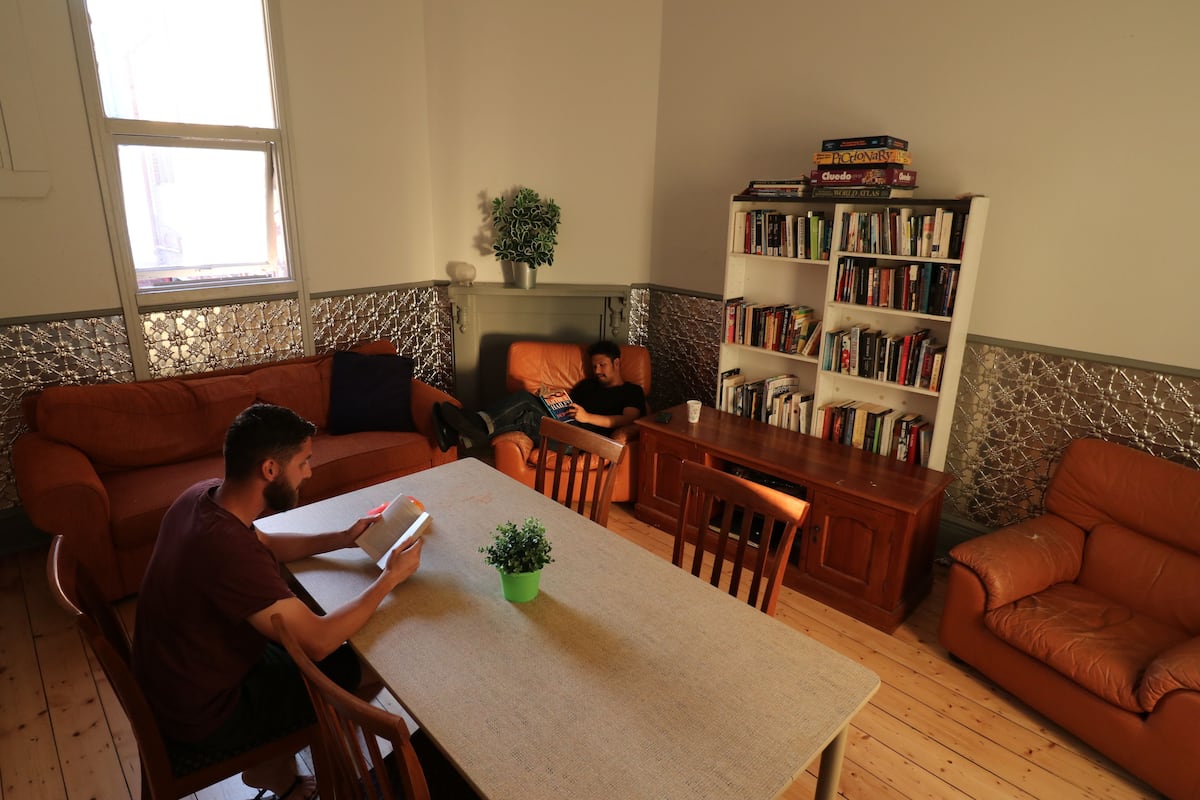 Ein Wohnzimmer mit einer Couch, einem Esstisch und einem Bücherregal.