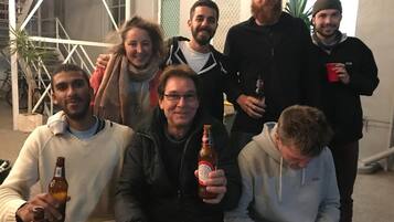 Een groep mensen in een kamer met een trap en een plant.
