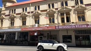 A historic building with a clock tower, Korean BBQ & Steamboat buffet, and Britannia on William restaurant. - Britannia on William - Hostel (Perth)