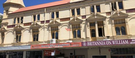 A historic building with a clock tower, Korean BBQ & Steamboat buffet, and Britannia on William restaurant.