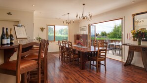 A dining area with wooden furniture, a chandelier, and a view of the outdoors. - Chalet Eiger Lodge (Taupo)