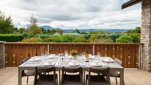 A dining table set outdoors with a view of a mountainous landscape. - Chalet Eiger Lodge (Taupo)