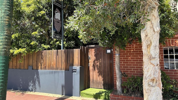 A wooden fence with a mailbox and a number '107' sign.
