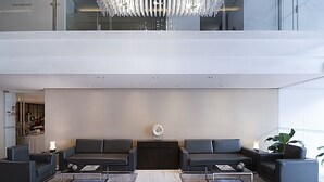 Un hall moderno con dos sofás, una mesa de centro y una araña.
