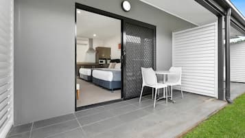 A modern house with a sliding glass door leading to a bedroom with a bed and a desk.