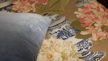 A pillow with a floral pattern and a tablecloth with a blue and white design.