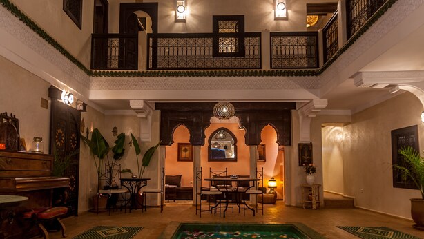 Un vestíbulo amplio con piscina, zona de comedor y escalera que sube a un nivel superior.