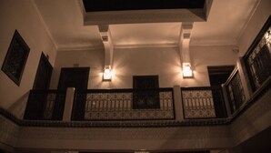 Una escalera con barandillas ornamentales y luces empotradas en la pared.