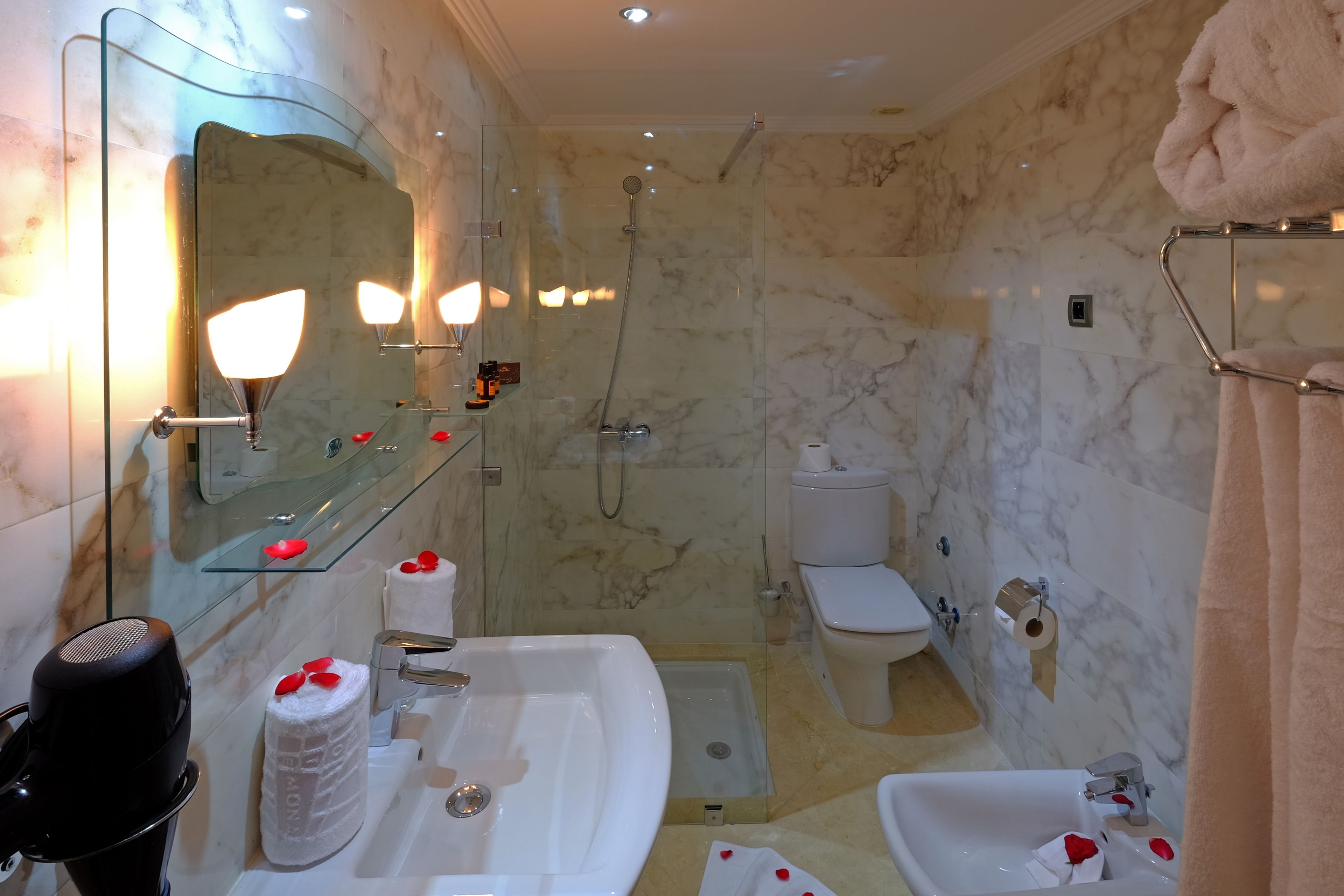 Ein Badezimmer mit Duschkabine, Waschbecken in Weiß und Toilette.