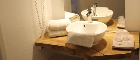 A bathroom with a white sink, a mirror, a towel rack, and a hairdryer.