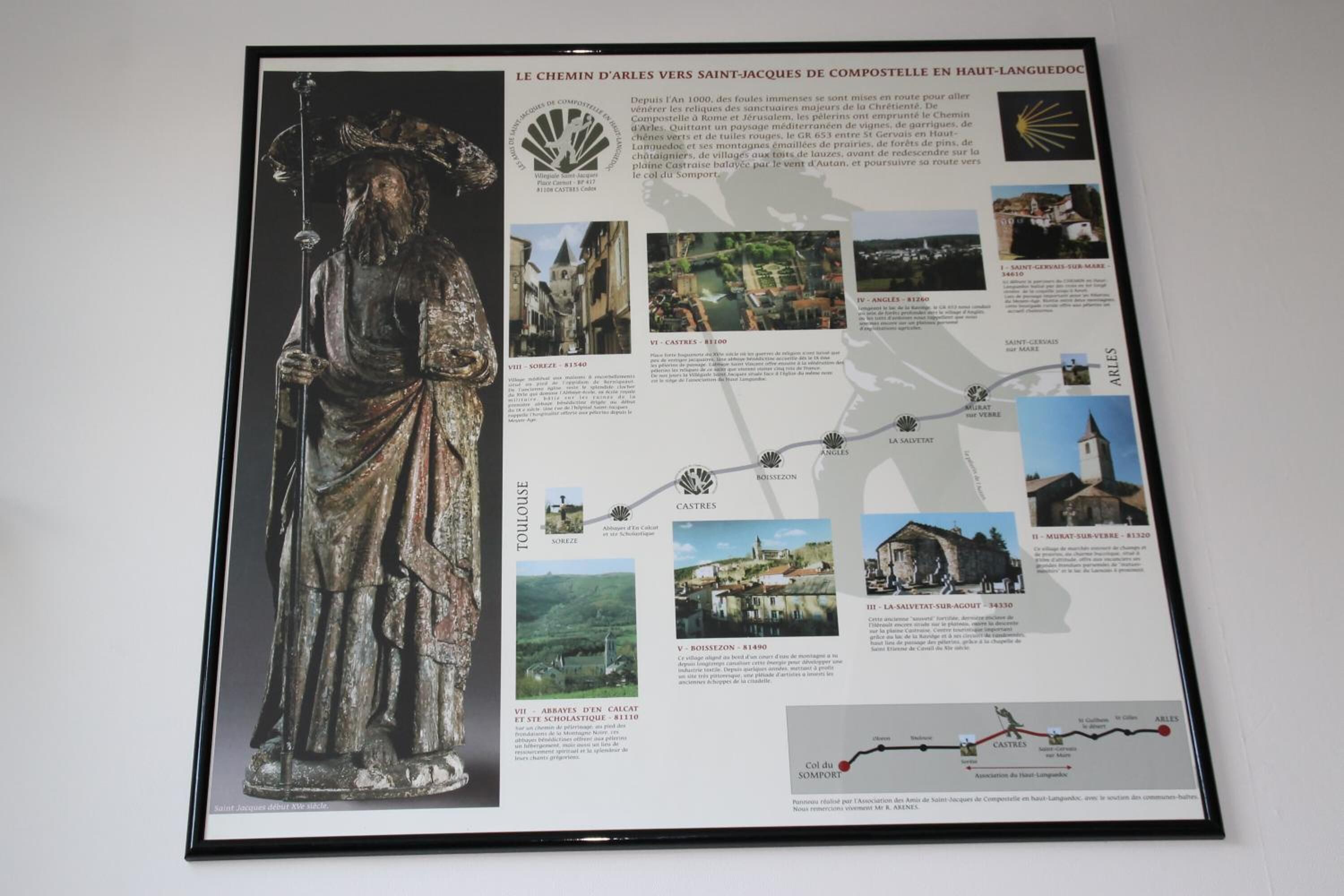 Un cartel informativo enmarcado con una estatua, texto y un mapa.
