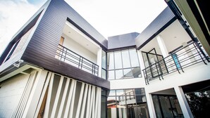 Un edificio moderno de varios pisos con techo plano, ventanas amplias y balcones.
