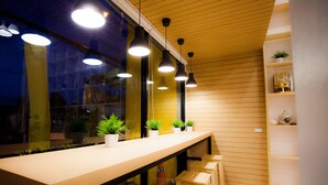 Un interior moderno con mostrador de madera, iluminación colgante y plantas en macetas.