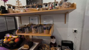 Un bufé de desayuno con diversos alimentos y decoraciones, incluyendo un letrero que dice "Le Bar".