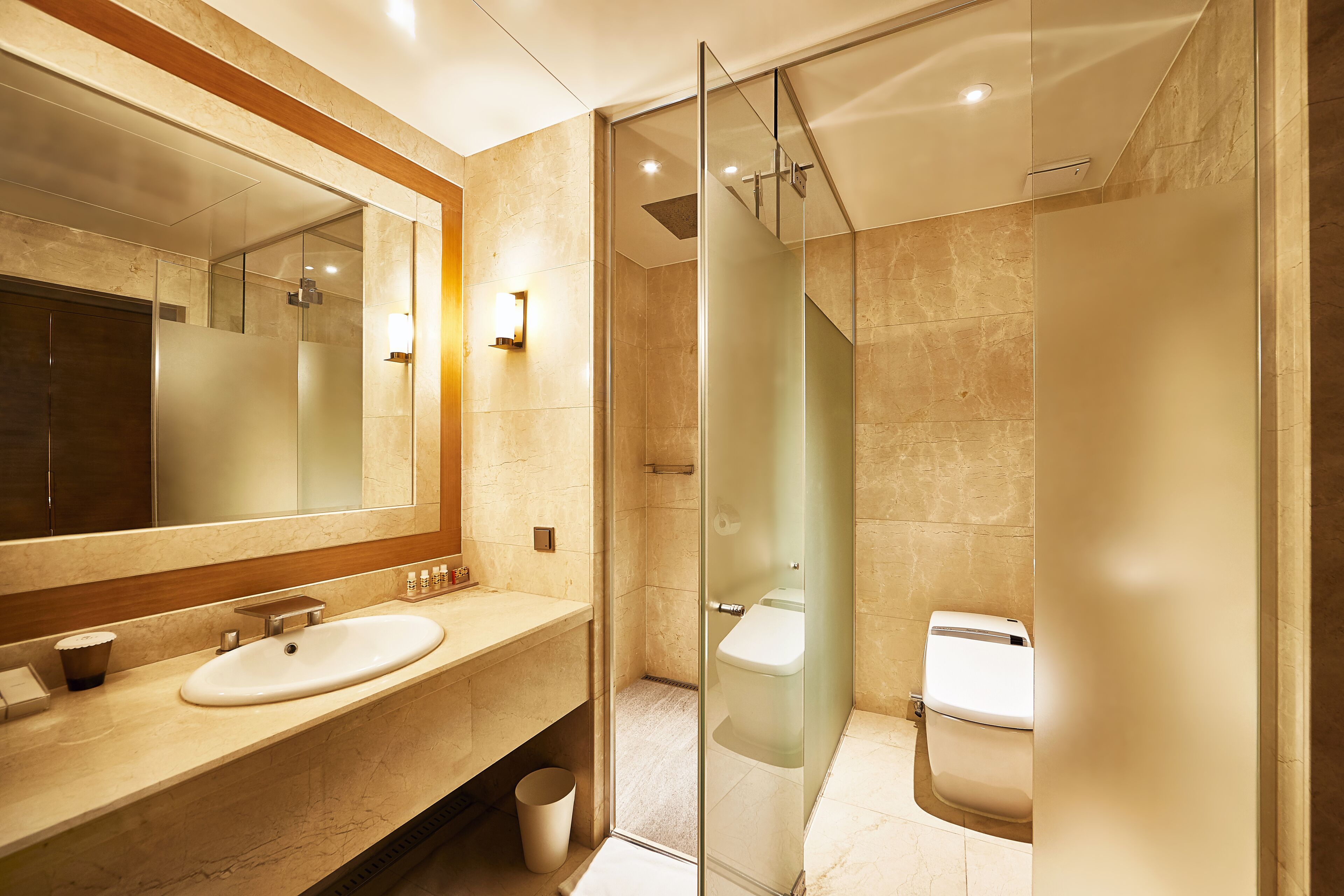 Une salle de bain moderne avec une douche à parois de verre, un grand miroir et un meuble-lavabo à deux vasques.