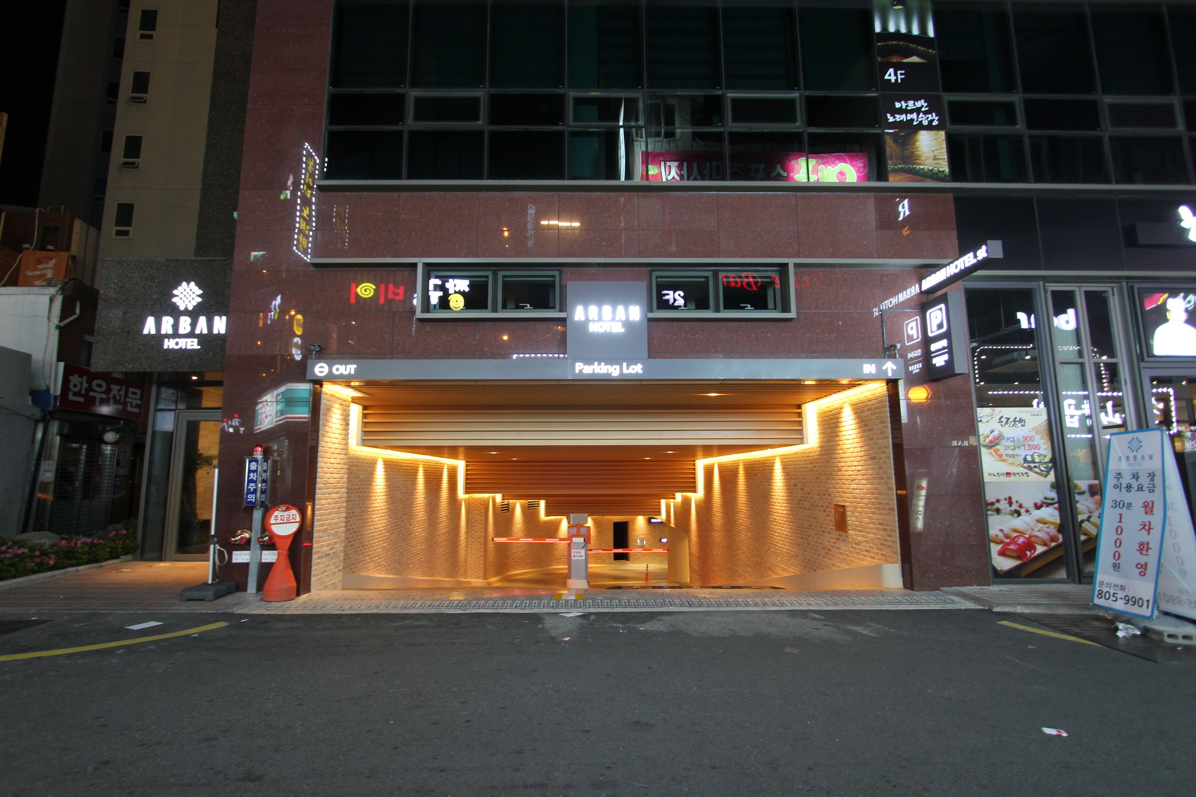 A hotel entrance with a parking lot sign, a sign indicating a 4F floor, and a visible restaurant sign.