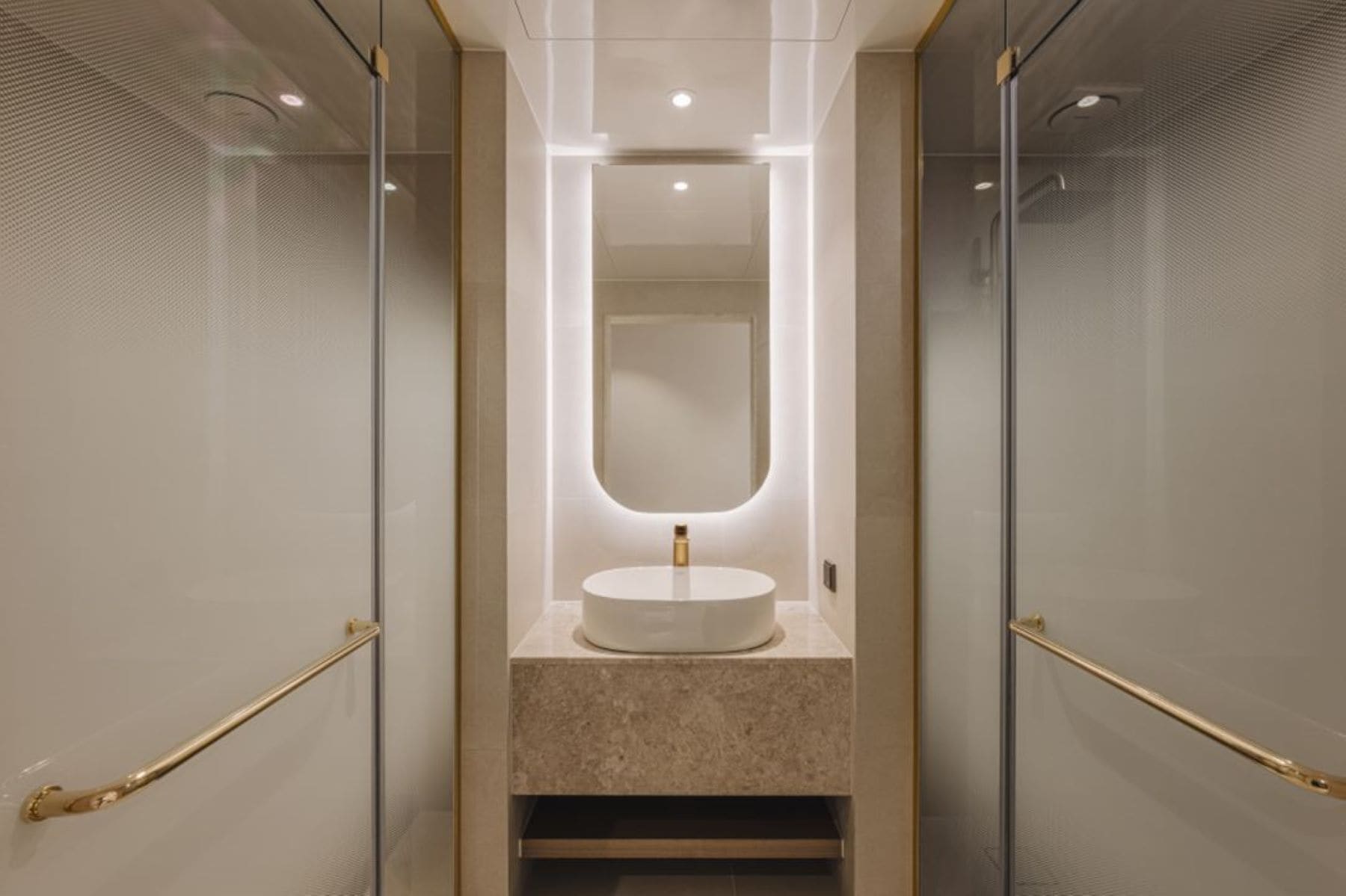 A modern bathroom with a round sink, a large mirror, and a glass partition.