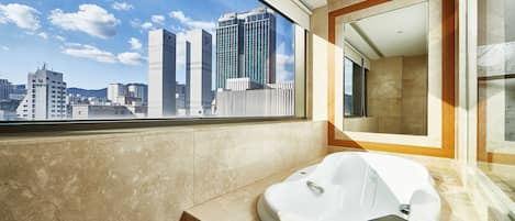 A modern bathroom with a large window, a bathtub, and a mirror.