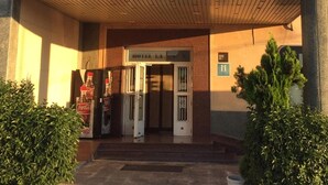 A hotel entrance with flags, a Coca-Cola sign, and a sign reading "HOTEL LA UNION". - Hotel La Unión (Humanes de Madrid)