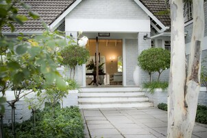 A house with a white exterior, a tiled roof, and a sign indicating a right of admission reserved.