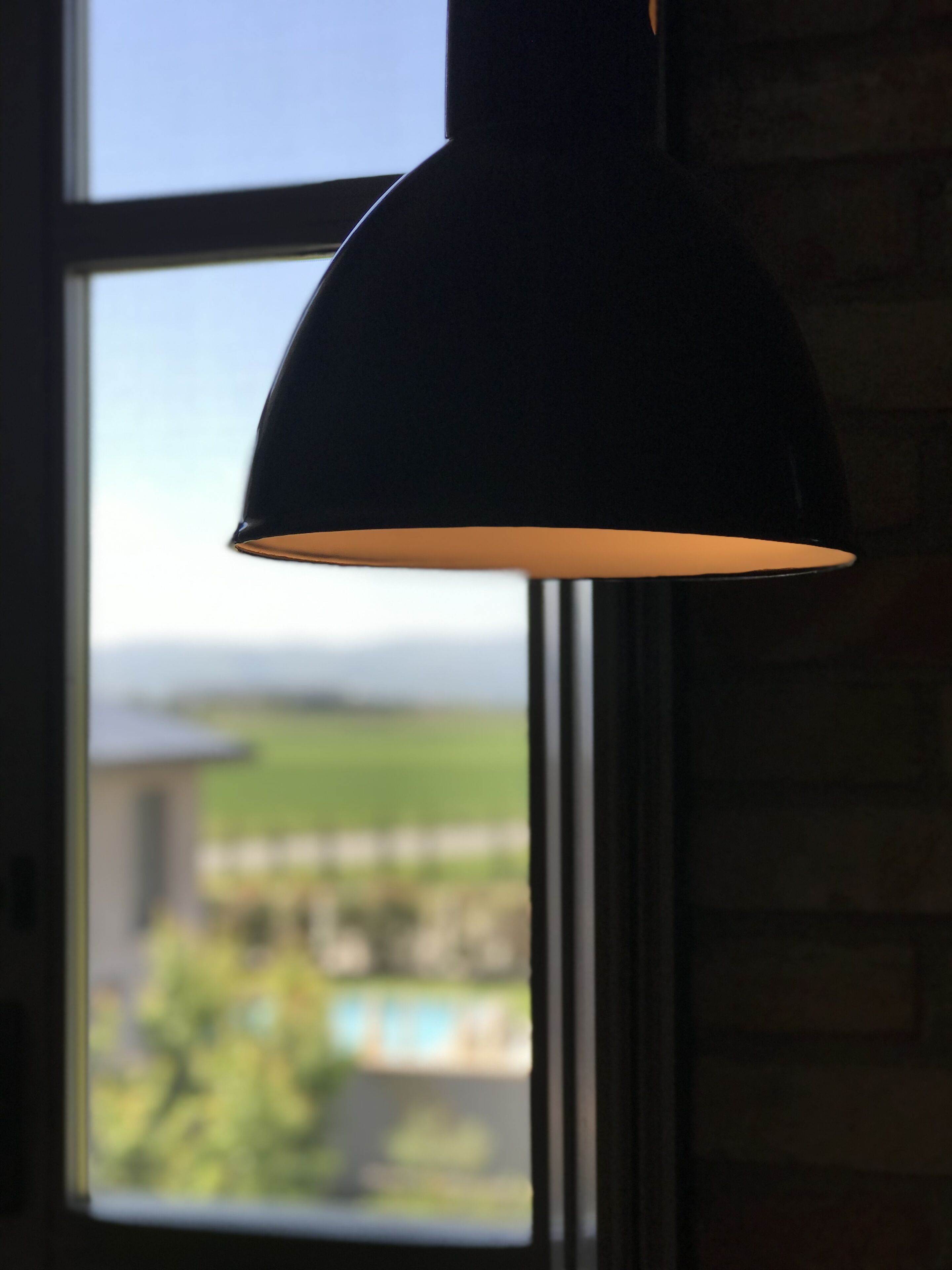 Una habitación con ventana y una lámpara colgante.
