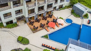 Een meerhoog hotel met terras en een zwembad.