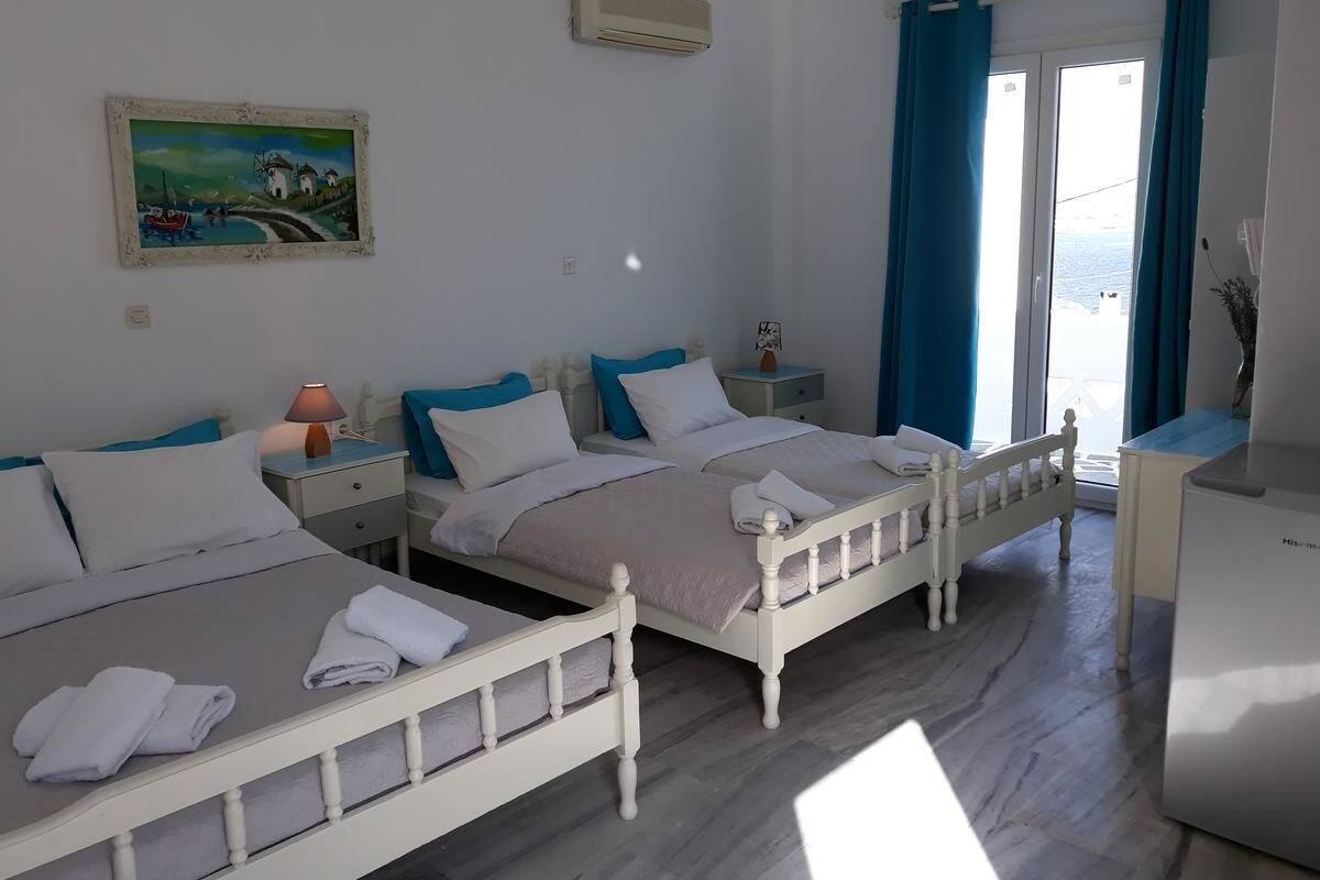 Habitación de hotel con dos camas, un escritorio, una silla, un televisor y un cuadro en la pared.