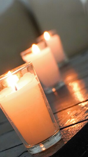 Three lit candles in clear glass holders on a wooden surface. - Weedan Hotel & Spa (Oulad Hassoune)