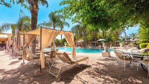 A poolside area with lounge chairs, umbrellas, and a pool. - Weedan Hotel & Spa (Oulad Hassoune)