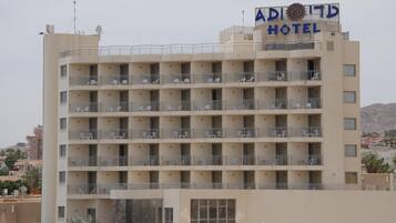 A multi-story hotel with balconies and a sign indicating it is a hotel.