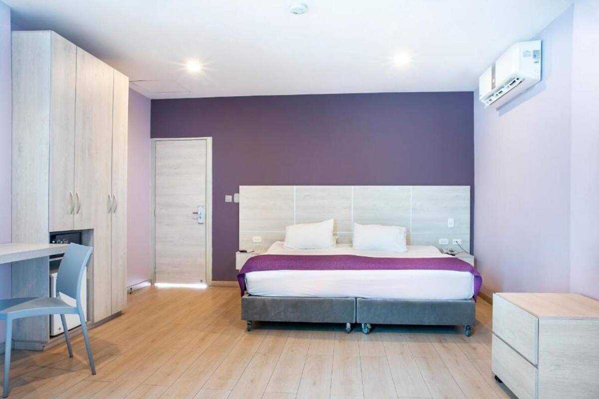 Une chambre à coucher avec un lit, un bureau et une armoire.