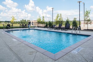 Una piscina al aire libre de temporada, sillones reclinables de piscina