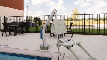 Enjoy a refreshing swim in the pool surrounded by a seating area with tables and chairs.