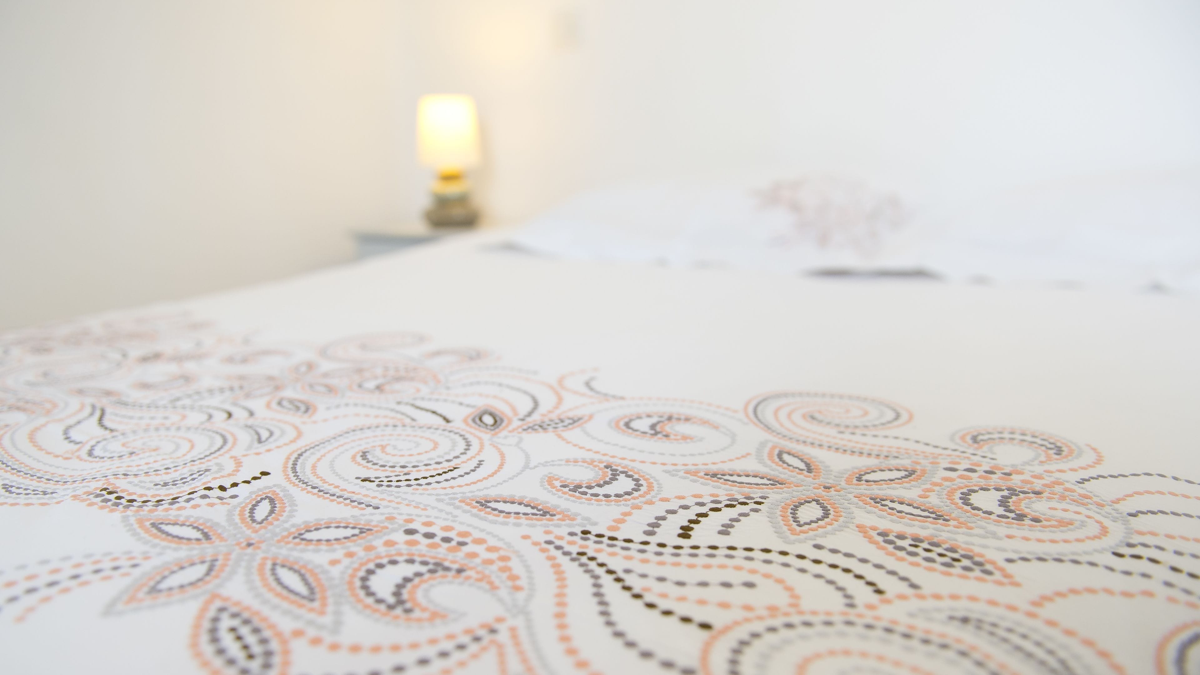 Primer plano de una cama con una colcha estampada.
