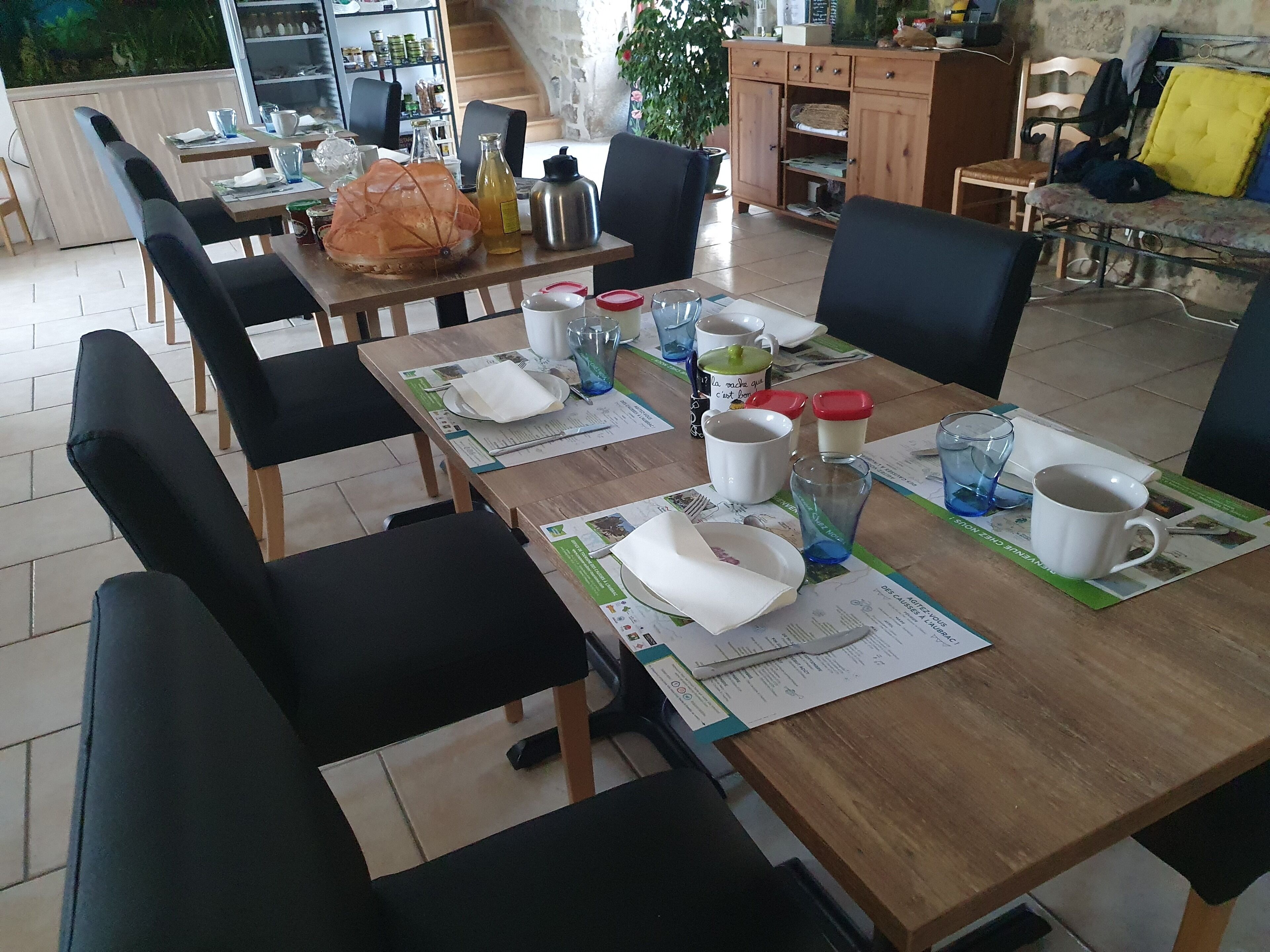 En matplats med bord som är dukade för frukost, inklusive tallrikar, koppar och en vattenkokare.