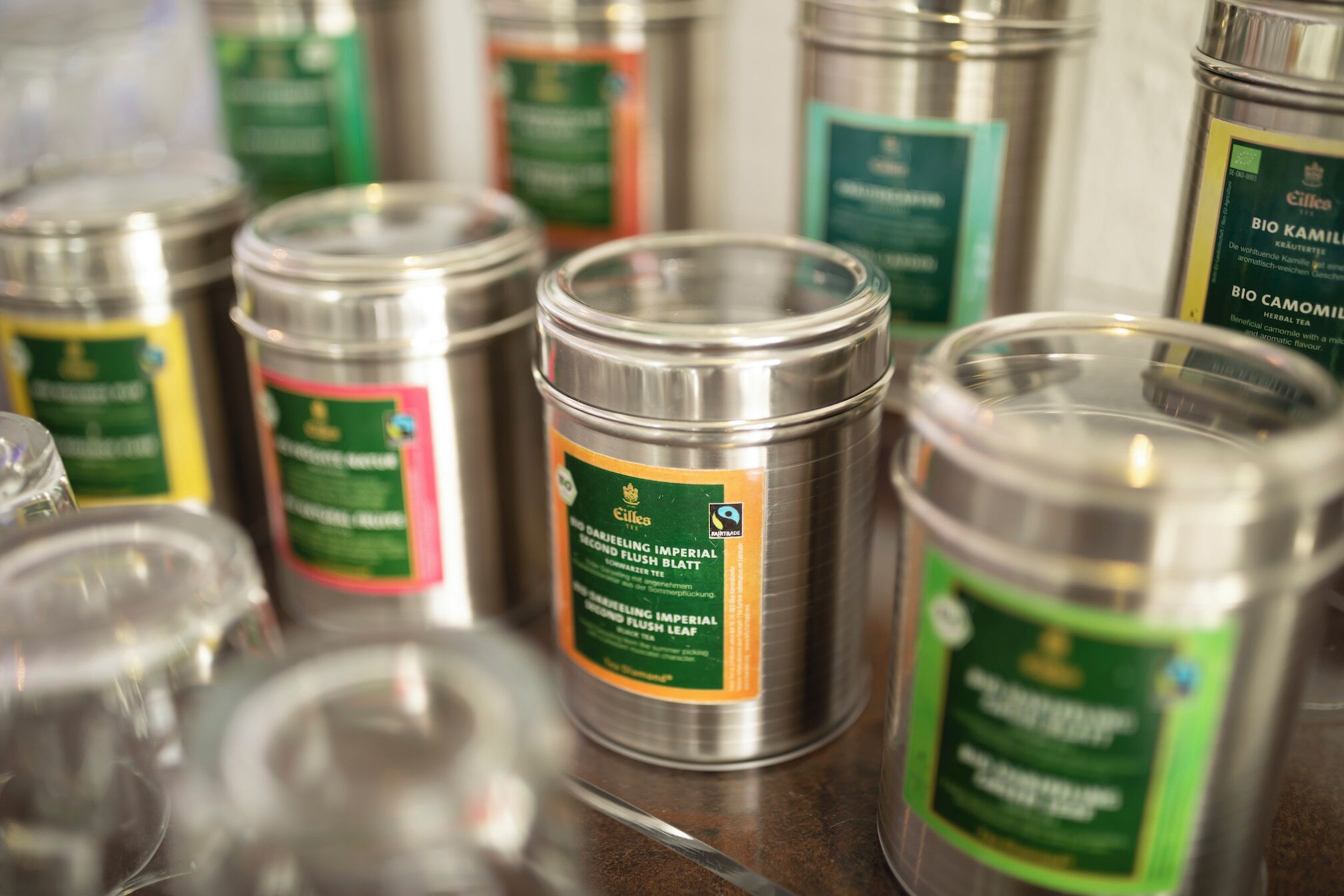 A collection of metal containers with labels, likely containing herbal tea or similar products.
