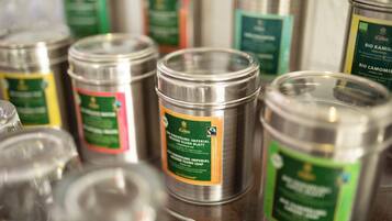 A collection of metal containers with labels, likely containing herbal tea or similar products.