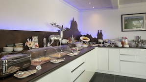 Un buffet garni de divers plats et agrémenté d’une statue de cerf décorative.