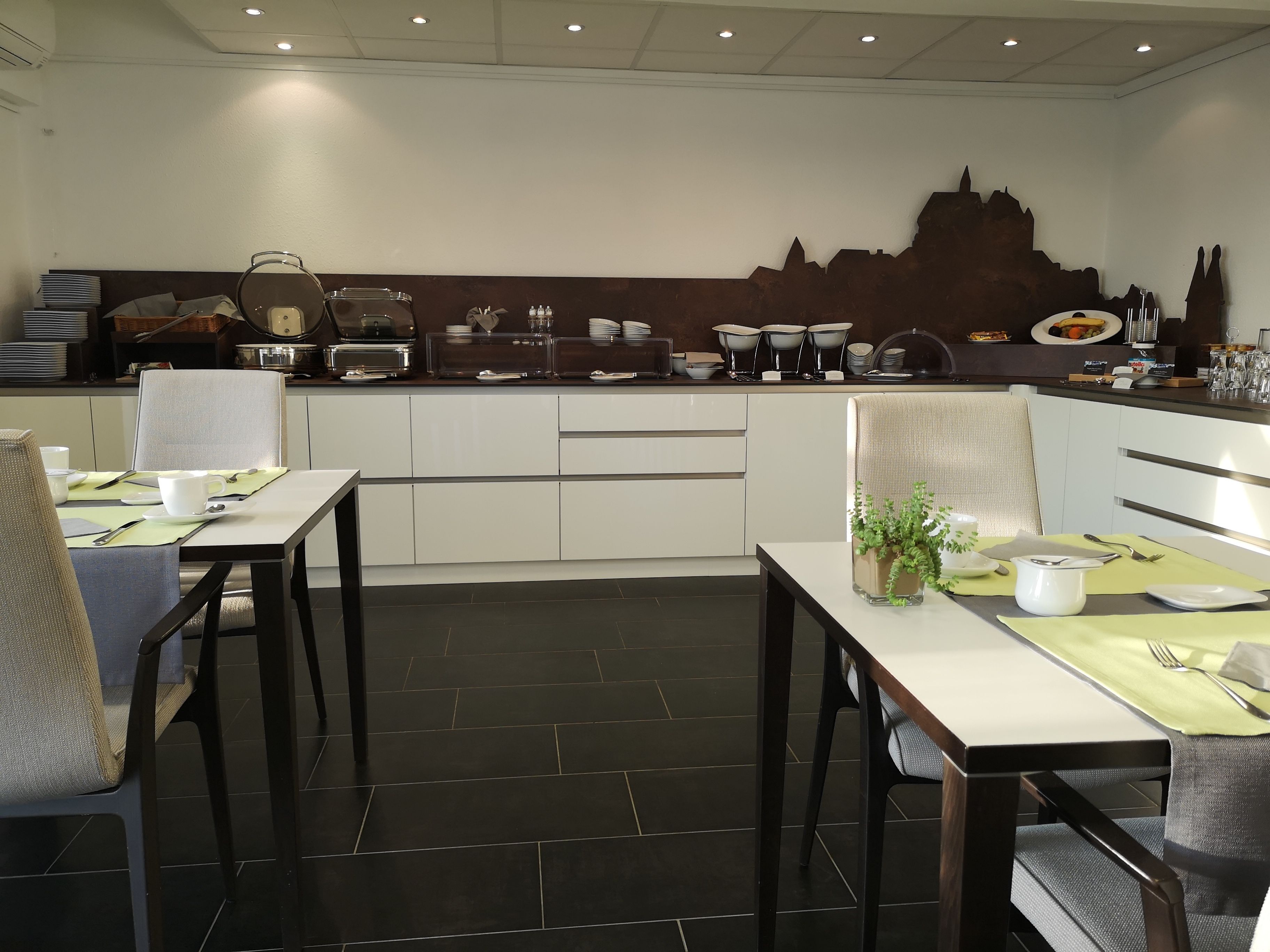 Zona pranzo moderna con buffet, che offre una varietà di piatti e una parete decorativa.