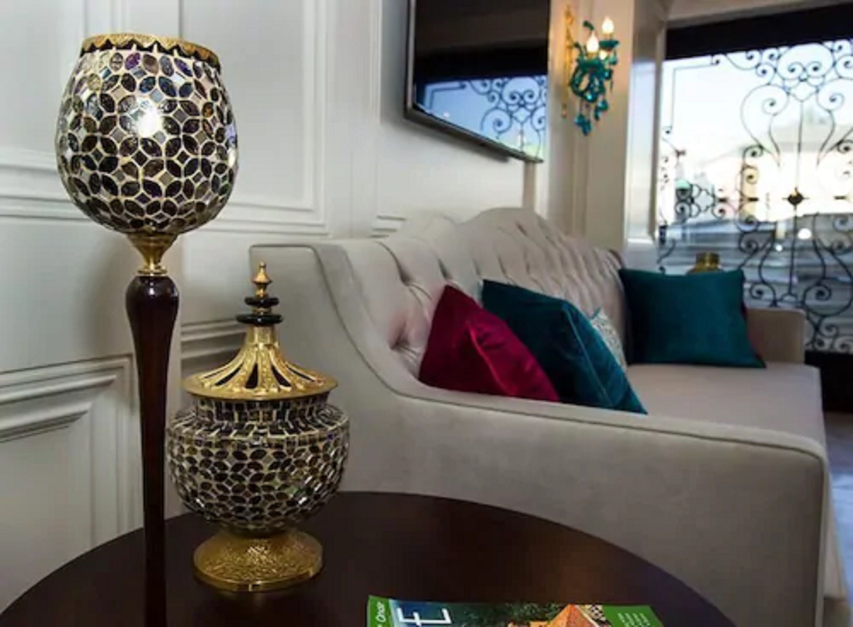 Une pièce comprenant un canapé, des lampes décoratives et un téléviseur.