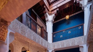 Une cour intérieure dotée d’une cheminée, d’espaces aménagés pour s’asseoir et de lustres décoratifs.