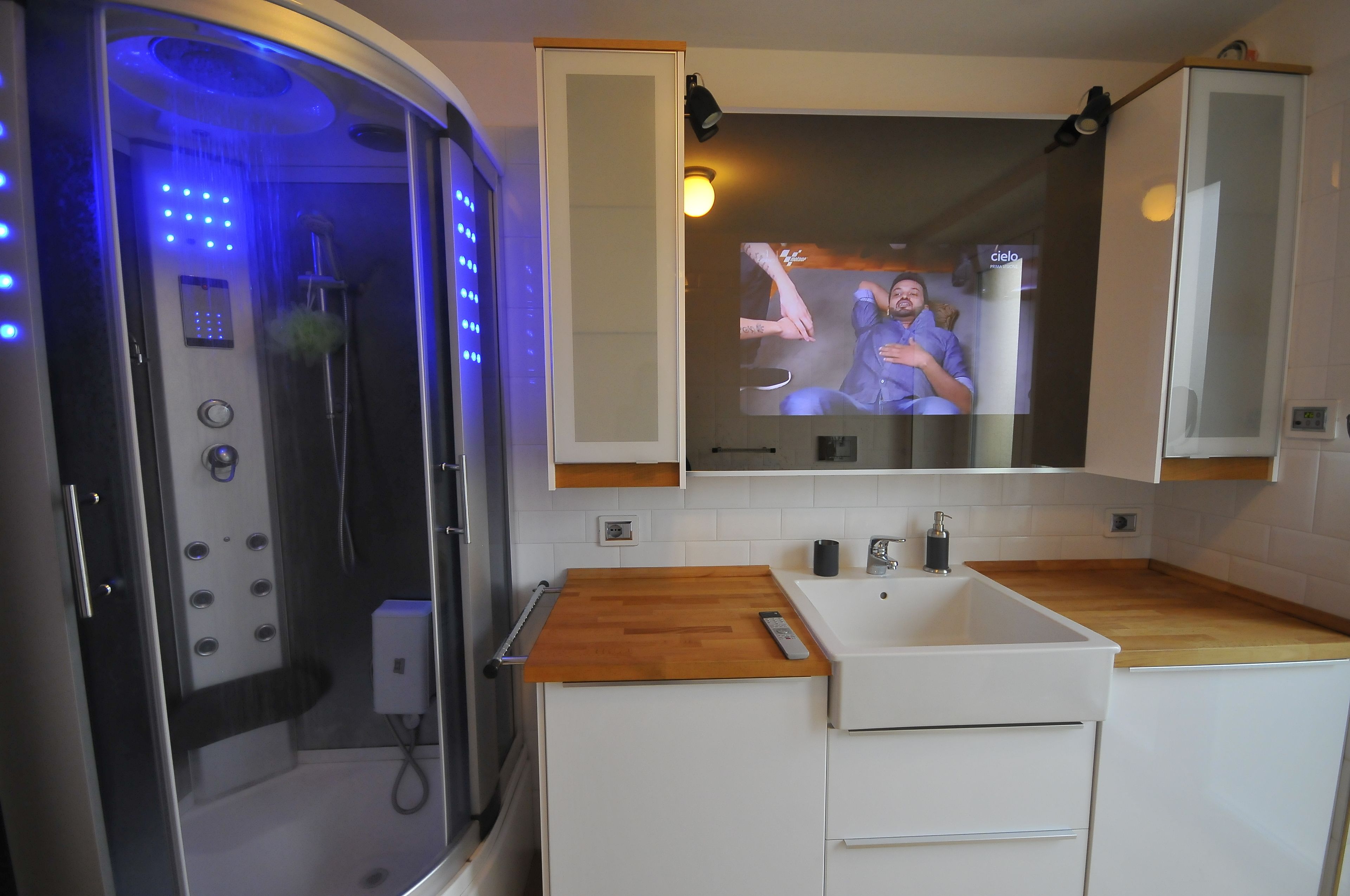 A modern bathroom with a shower, a sink, and a mirror.