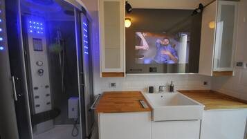 A modern bathroom with a shower, a sink, and a mirror.