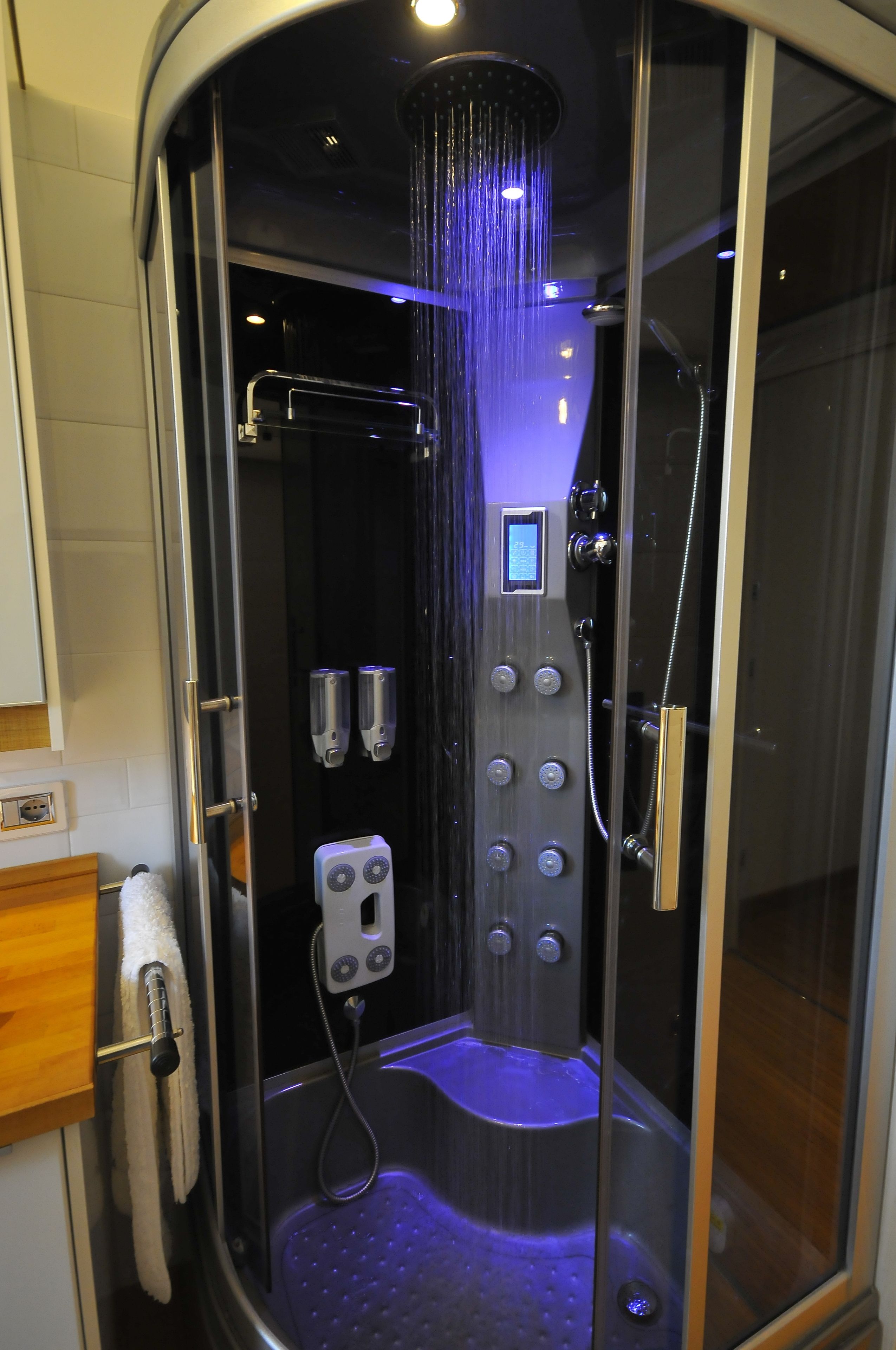 Eine moderne Dusche mit mehreren Brauseköpfen und einer Bedienkonsole.