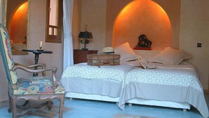 A bedroom with two beds, a chair, a lamp, and a mirror. - MAROC LODGE Atlas Mountain Retreat  (Amizmiz)