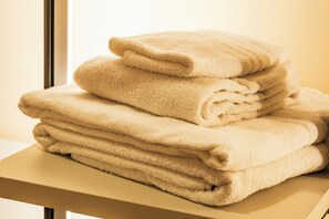A stack of beige towels on a wooden table. - Affittacamere Al Seminario (Tivoli)