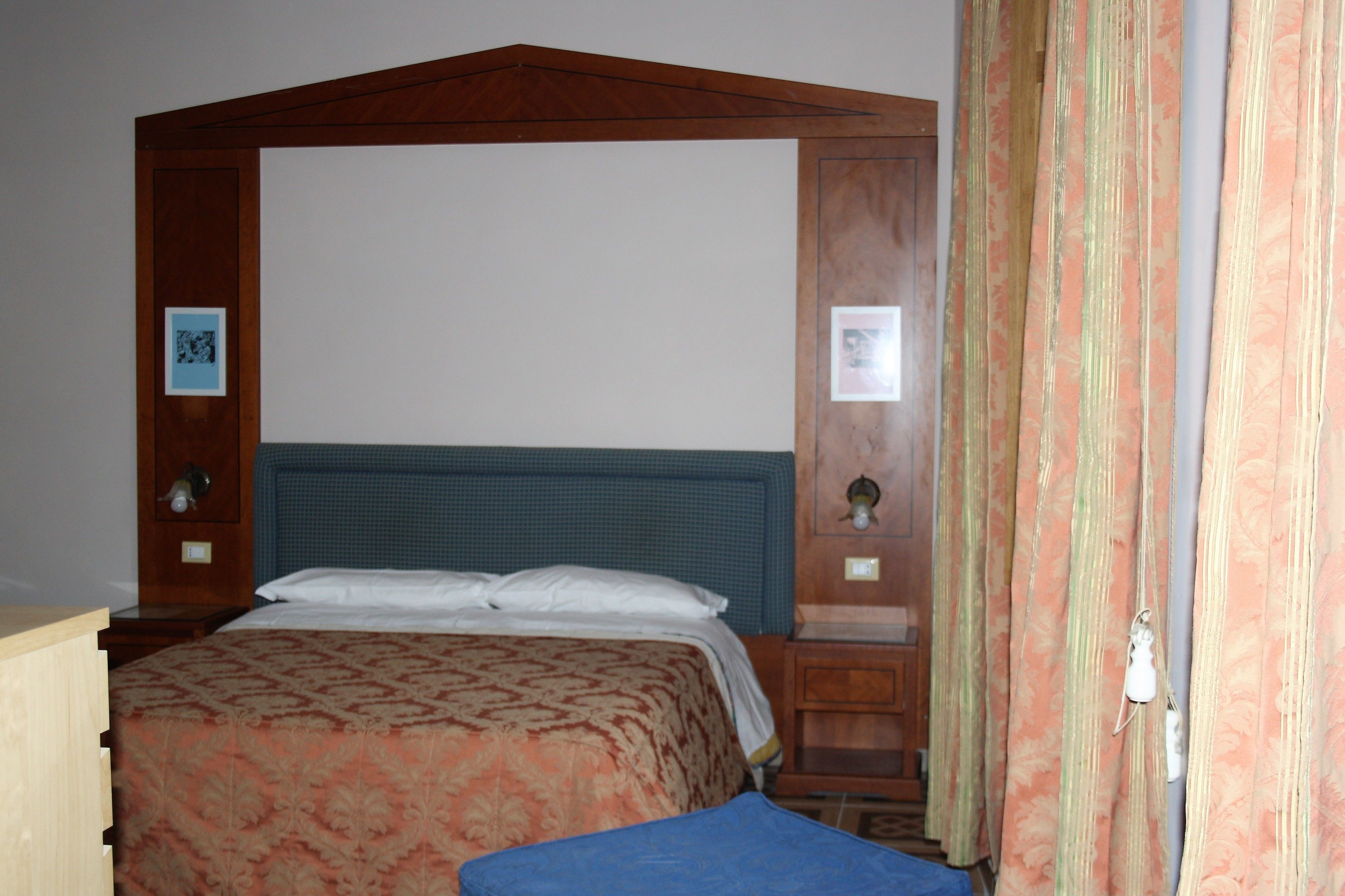 A bedroom with a four-poster bed, wooden headboard, and a nightstand.
