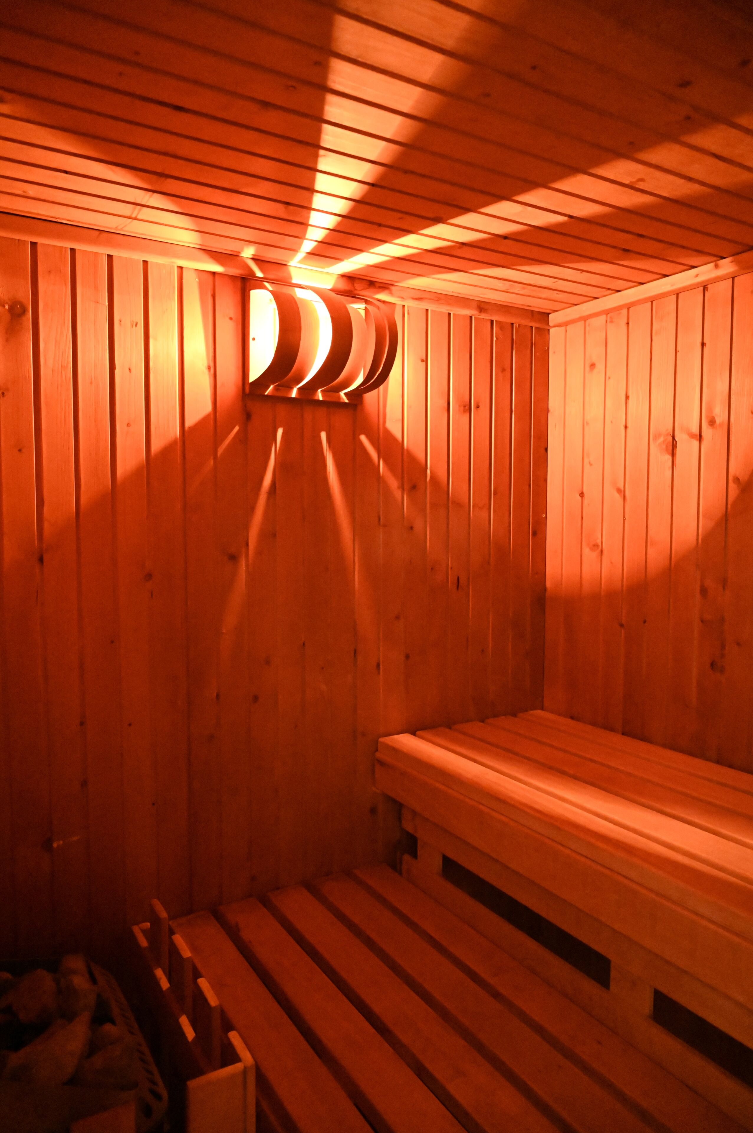 Ein Raum mit Sauna, Holzvertäfelung und Bänken.